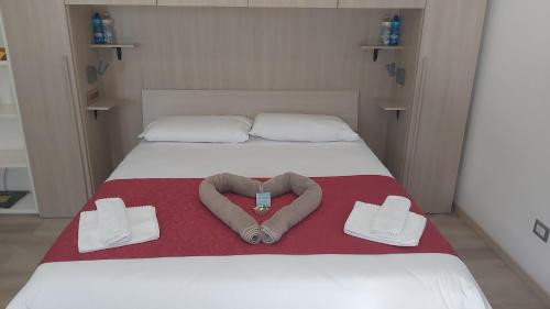 a bedroom with a bed with a heart shapedvisorvisorangering at Metro&Mare House in Lido di Ostia