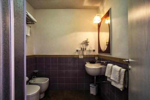 a bathroom with two sinks and a toilet and a mirror at Hotel O'scià in Lampedusa