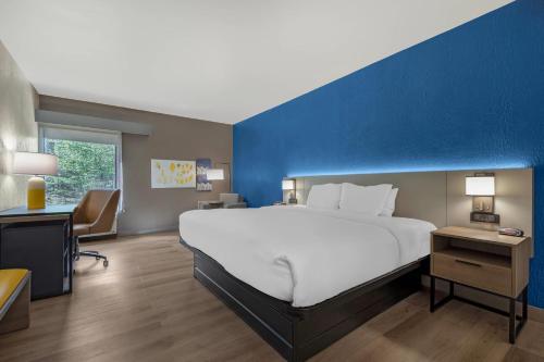 a bedroom with a large white bed and a blue wall at Comfort Inn West Hazleton in West Hazleton