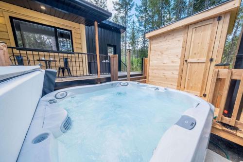 a hot tub on the deck of a tiny house at Spa & Riverside - Le Ptit Cool Des Bois in Trois Rives