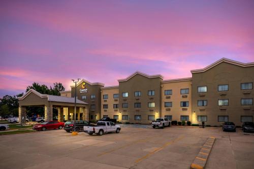 a hotel with cars parked in a parking lot at Comfort Inn & Suites Covington - Mandeville in Covington