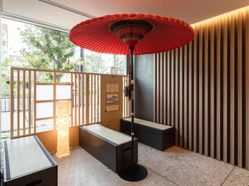 a red umbrella in a room with a bench at Comfort Hotel ERA Kyoto Toji in Kyoto