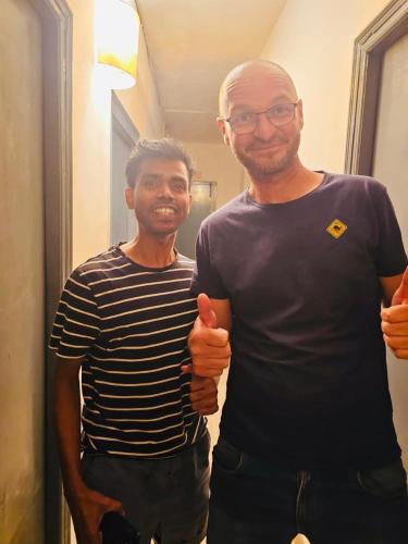two men giving thumbs up while standing in a hallway at Bed & Chai in New Delhi