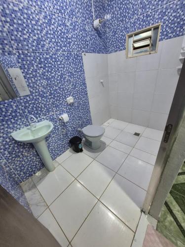 a blue bathroom with a toilet and a sink at Aconchego do Peruaçu in Itacarambi