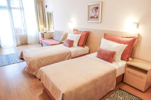 a hotel room with two beds and a couch at Hotel Acropolis in Varna City