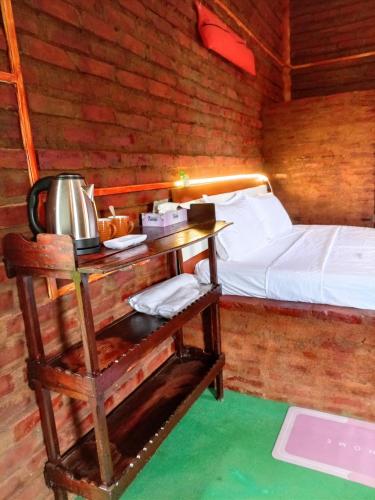 a room with a bed and a table with a tea kettle at Padiwatte Residencies in Kandy