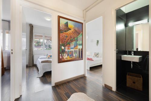 ein Badezimmer mit einem Gemälde an der Wand neben einem Schlafzimmer in der Unterkunft Melody in Sitges