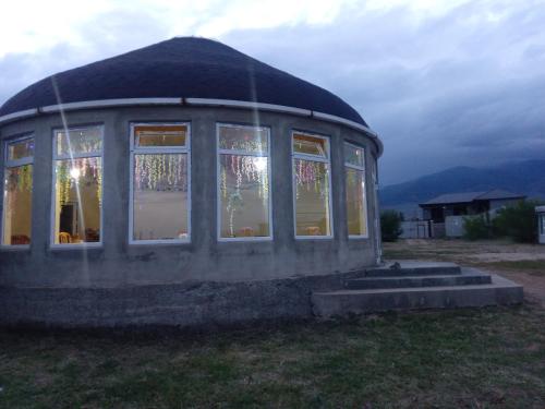 a round dome house with windows in a field at Кафе Кочевник in Chon-Sary-Oy