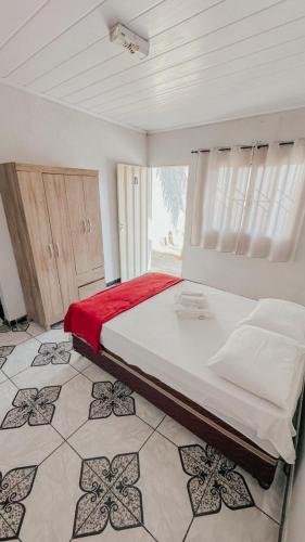 a bedroom with a large bed and a window at Aconchego do Peruaçu in Itacarambi