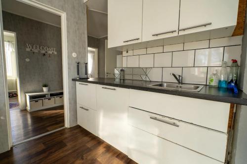 a kitchen with white cabinets and a counter top at Private Villa with parking - Skellefteå in Skellefteå
