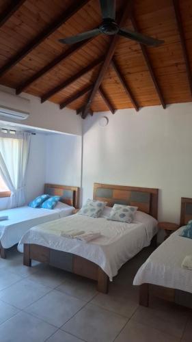 two beds in a room with a ceiling fan at Casa de Playa Antawara in El Porvenir