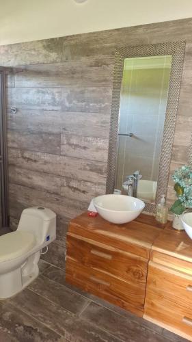 a bathroom with a sink and a toilet and a mirror at Casa de Playa Antawara in El Porvenir