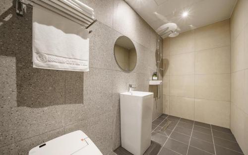 a bathroom with a white toilet and a mirror at Daegu Brown Dot Hotel Kyungpook National University in Daegu