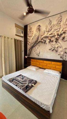 a bedroom with a bed with a bird on the wall at Kanak Bihari Enclave in Ayodhya