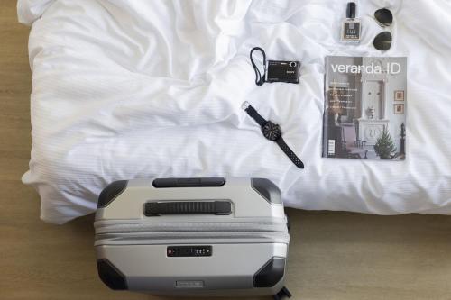 a toaster and keys on a bed next to at Solo Society Hybrid Hotel Vilnius in Vilnius