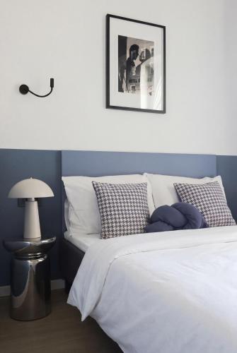 a bedroom with a white bed and a picture on the wall at Solo Society Hybrid Hotel Vilnius in Vilnius