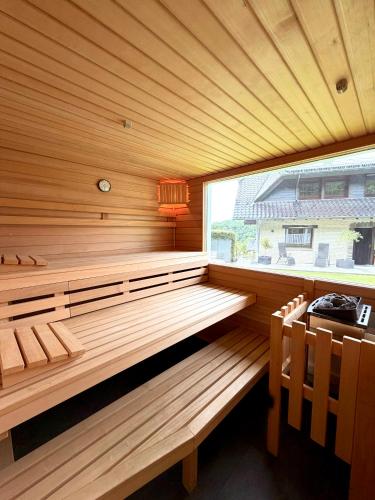 eine Holzsauna mit Fenster und zwei Stühlen in der Unterkunft Villa Eifelblick Sauna&Wellness Apartment in Heimbach