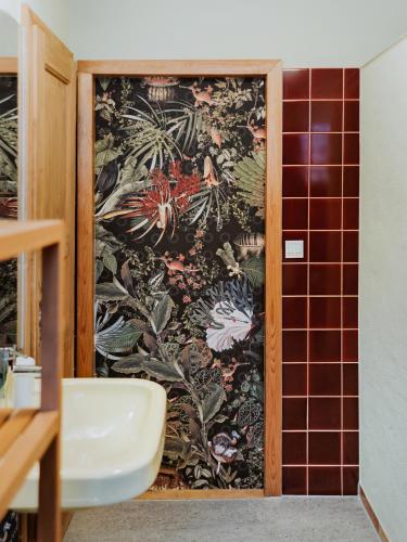 a bathroom with a wall with a floral pattern at MYA Weinland Hotel Kobern-Gondorf in Kobern-Gondorf