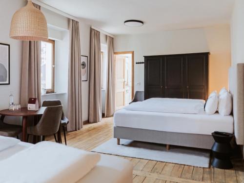a hotel room with two beds and a table at MYA Weinland Hotel Kobern-Gondorf in Kobern-Gondorf