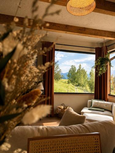 a living room with a couch and a large window at The White House Tripsylvania in Şirnea