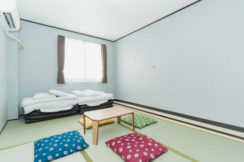 a room with two beds and a table and pillows at Portside Stay 石垣島 離島ターミナル徒歩3分 バスターミナル前 室内リニューアル in Ishigaki Island