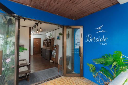an entrance to a building with a blue wall at Portside Stay 石垣島 離島ターミナル徒歩3分 バスターミナル前 室内リニューアル in Ishigaki Island