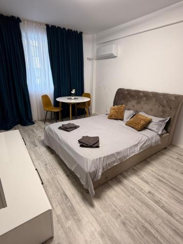 a bedroom with a large bed and a table at Happy Studio 1 in Craiova