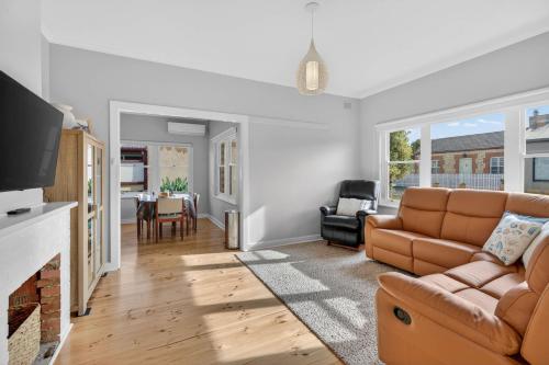 a living room with a couch and a fireplace at Hutchinson House in Goolwa