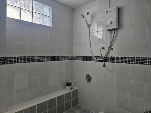 a shower in a tiled bathroom with a sink at Cozy rooms Asoke in Bangkok