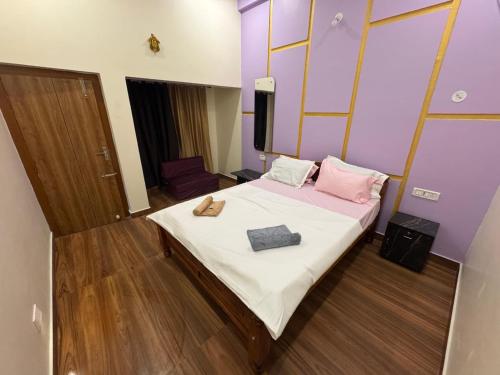 a bedroom with a bed with pink and white sheets at Golden Waves Guest House in Mahabalipuram