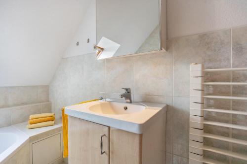 a bathroom with a sink and a mirror at Sonnengelb - Fulgenhaus in Klein Bollhagen