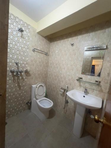 a bathroom with a toilet and a sink at Namaste Apartment in Pokhara