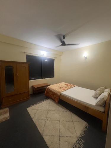 a bedroom with a bed and a flat screen tv at Namaste Apartment in Pokhara