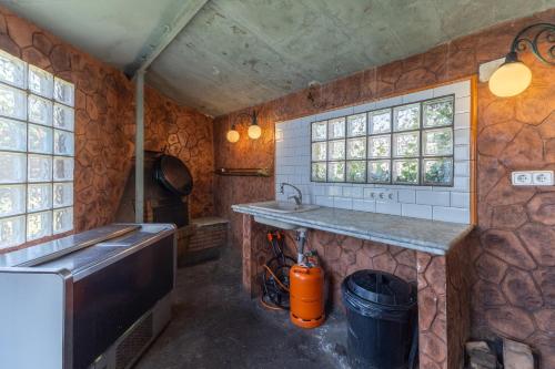 a kitchen with a counter and a sink and windows at Casa Viria in Navaluenga