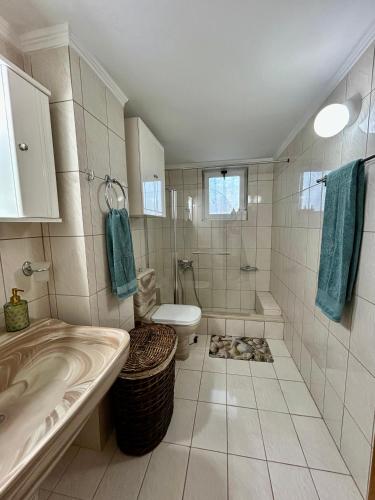 a bathroom with a sink and a toilet and a tub at Errant Blue House Kyllini in Kyllini