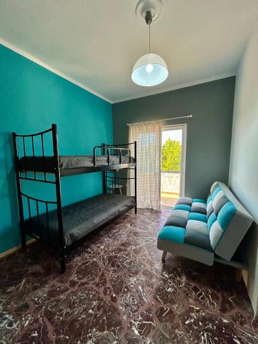 a room with two bunk beds and a couch at Errant Blue House Kyllini in Kyllini