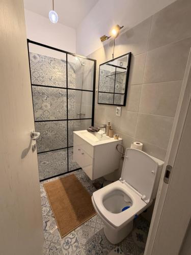 a bathroom with a white toilet and a sink at Happy Studio 1 in Craiova