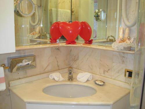 a bathroom with a sink with a red heart on it at Hotel Matilde in Marina di Massa
