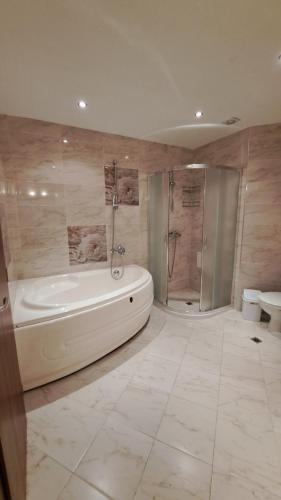 a large bathroom with a tub and a shower at Hotel Seasons 3 in Sunny Beach