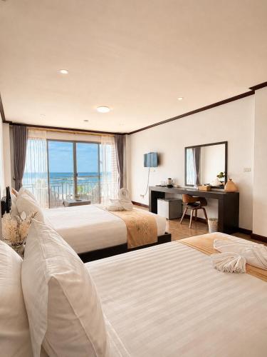 a hotel room with two beds and a view of the ocean at ClayHouse SAMUI Boutique Hotel in Koh Samui