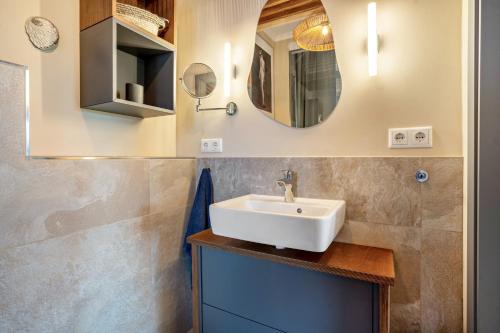 a bathroom with a sink and a mirror at Küstenblau - Fulgenhaus in Klein Bollhagen