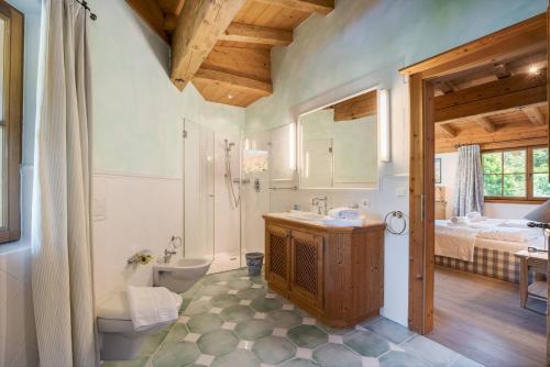 a bathroom with a sink and a toilet and a bed at Chalet Lebenberg Kitzbühel in Kitzbühel