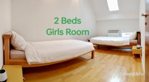 two beds in a room with the words beds girls room at Hostel Alfar in Sarajevo