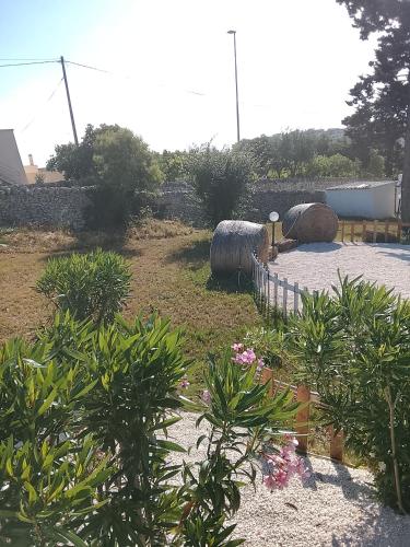 a garden with two large hay bales and plants at Trullo martina in Martina Franca