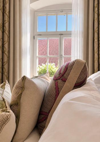 a bed with pillows sitting in front of a window at Adler Oberdorf in Langenargen