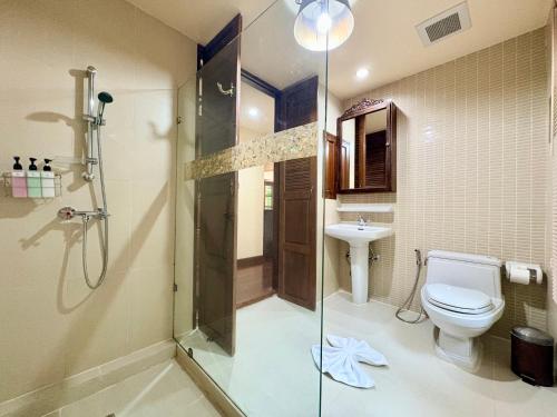 a bathroom with a shower and a toilet and a sink at Shewe Wana Suite Resort in Chiang Mai