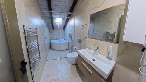 a bathroom with a sink and a toilet and a shower at Oborri Shkodran Boutique Hotel in Shkodër