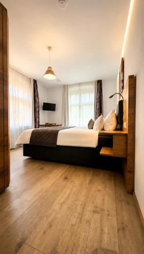 a large bedroom with a large bed and wooden floors at Adler Oberdorf in Langenargen