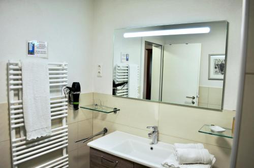 a bathroom with a sink and a mirror at Haus Hofer in Bramberg am Wildkogel