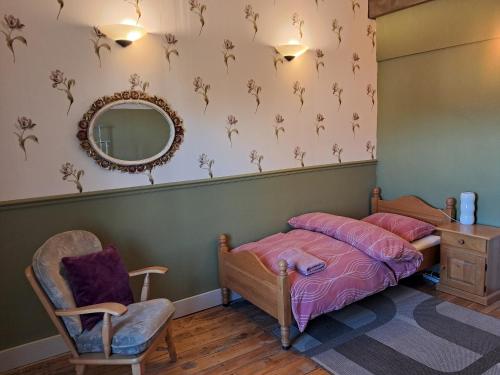 a bedroom with a bed and a mirror and a chair at Thunder Roadhouse in La Mothe-Saint-Héray